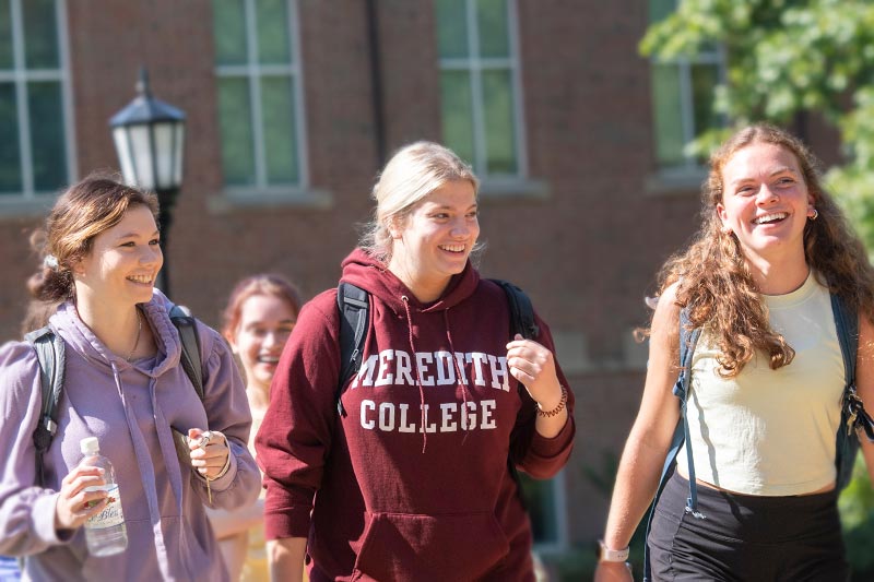 Three students walking to class on Meredith's campus.