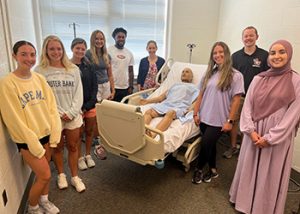 The Accelerated Dietitian Nutritionist Track first cohort of eight students with the nutrition patient dummy.